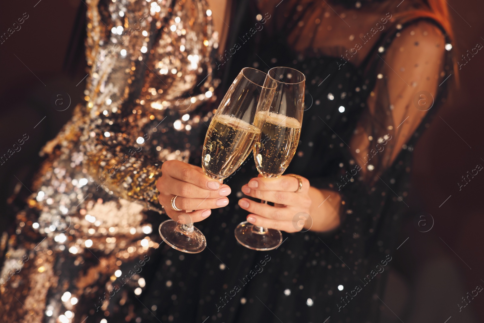 Photo of Women with glasses of sparkling wine celebrating New Year indoors, closeup