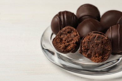 Photo of Many delicious chocolate truffles on white table, closeup. Space for text