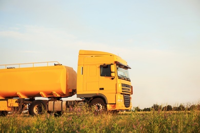 Photo of Modern yellow truck on country road. Space for text