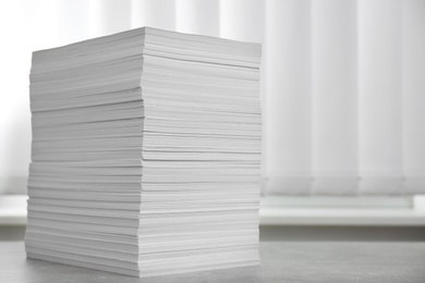 Photo of Stack of paper sheets on grey table. Space for text