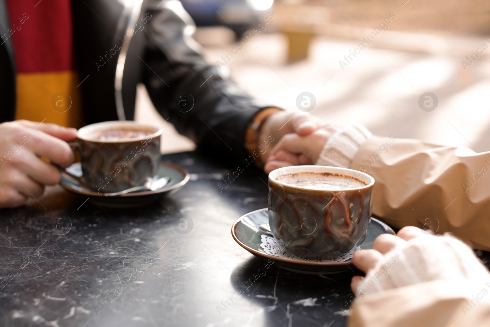 Photo of Couple enjoying tasty aromatic coffee at table, closeup view