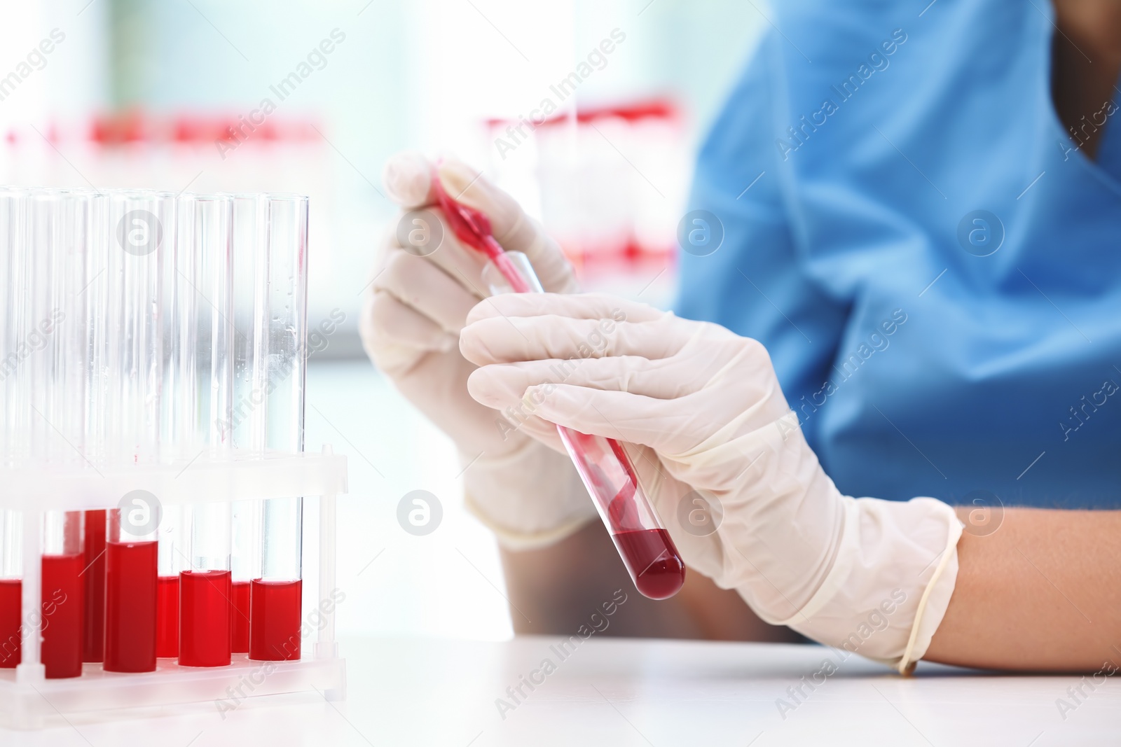 Photo of Scientist working with blood sample at table in laboratory