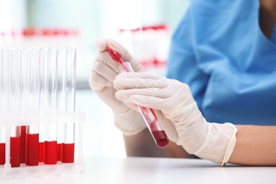 Scientist working with blood sample at table in laboratory