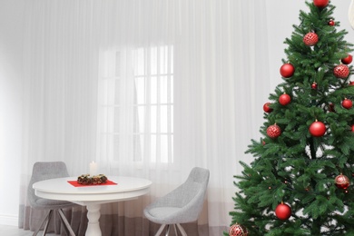 Photo of Stylish Christmas interior with fir tree, table and chairs