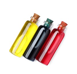 Glass bottles with different food coloring on white background, top view