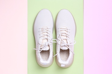 Photo of Stylish sporty sneakers on color background, top view