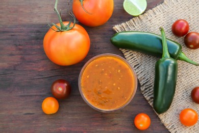 Photo of Tasty salsa sauce and ingredients on wooden table, flat lay