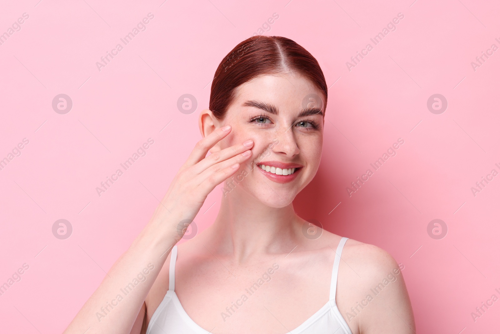 Photo of Portrait of smiling woman on pink background