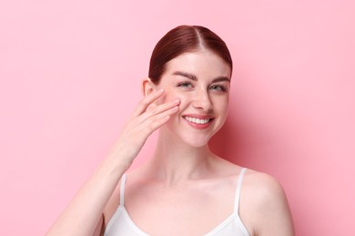 Portrait of smiling woman on pink background