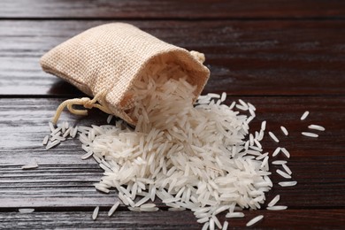 Photo of Raw basmati rice and bag on wooden table