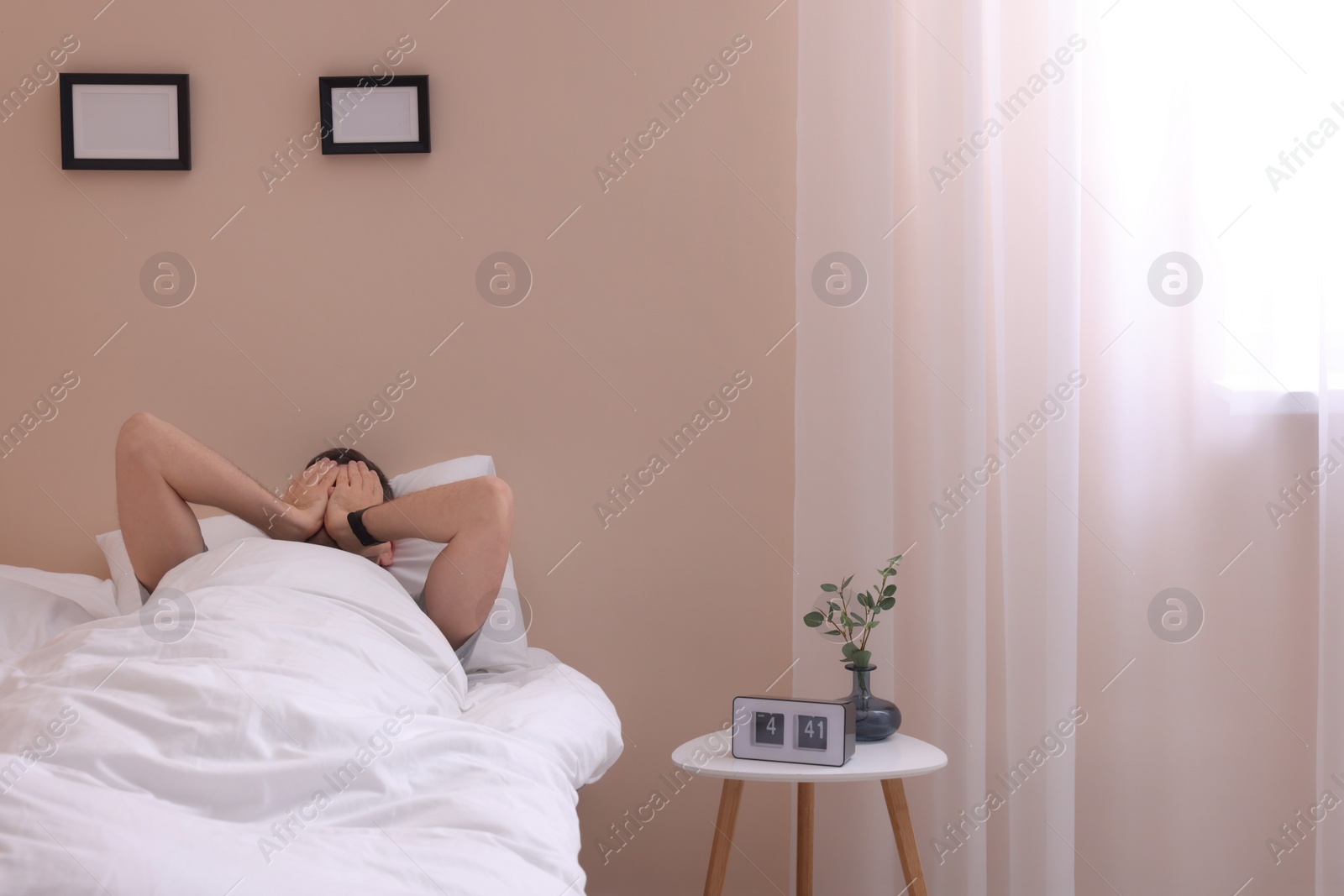 Photo of Sleepy man awaking in bed at home