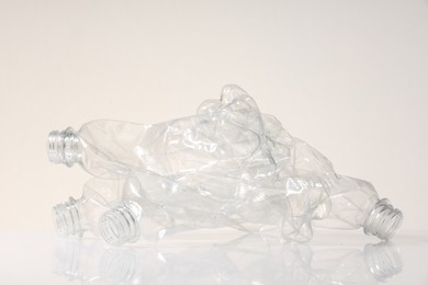 Photo of Crumpled disposable plastic bottles on white background