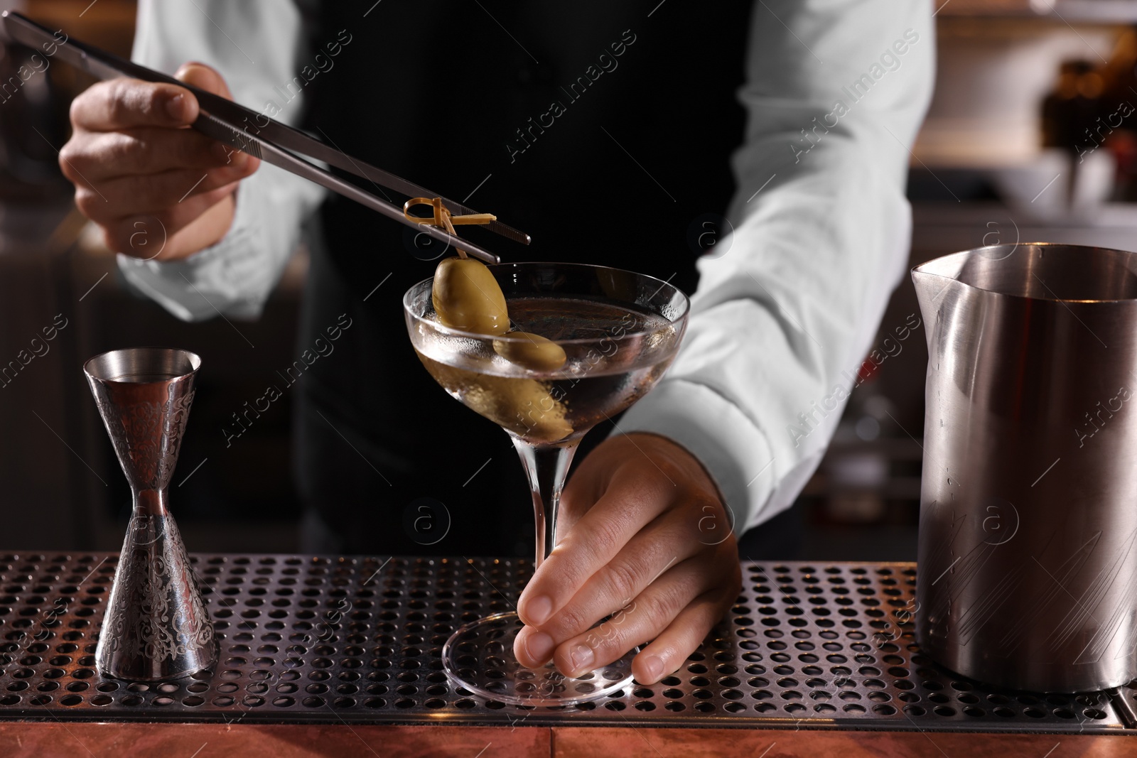 Photo of Bartender preparing fresh Martini cocktail at bar counter, closeup