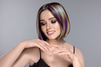 Image of Hair styling. Attractive woman with colorful hair on grey background