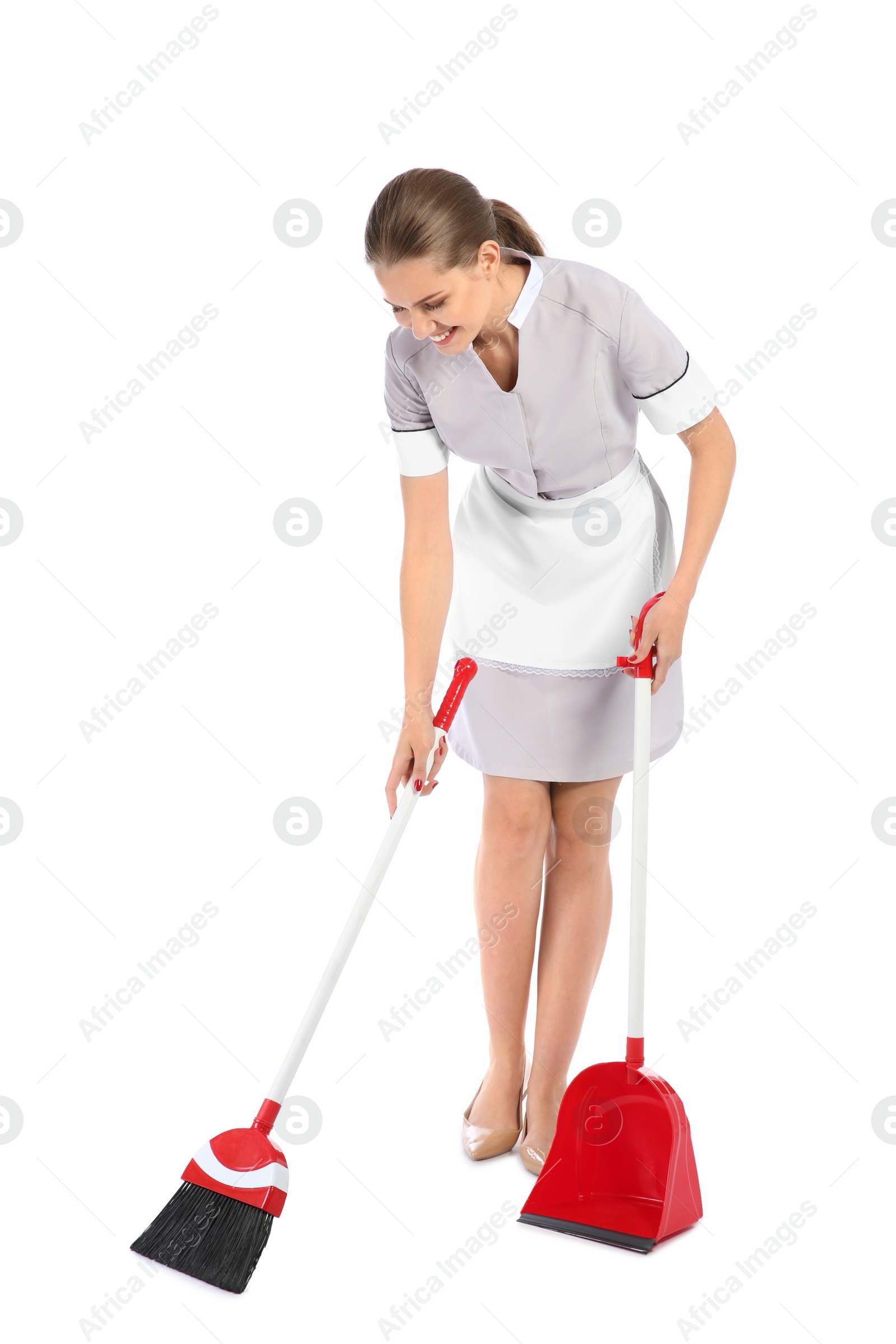 Photo of Young chambermaid with broom and dustpan on white background