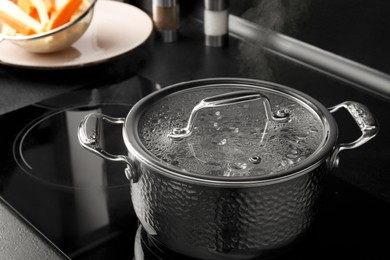 Pot with boiling water on stove in kitchen