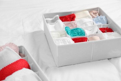 Photo of Organizers with stylish women's underwear on bed