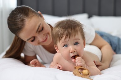 Photo of Happy mother with her baby on bed at home