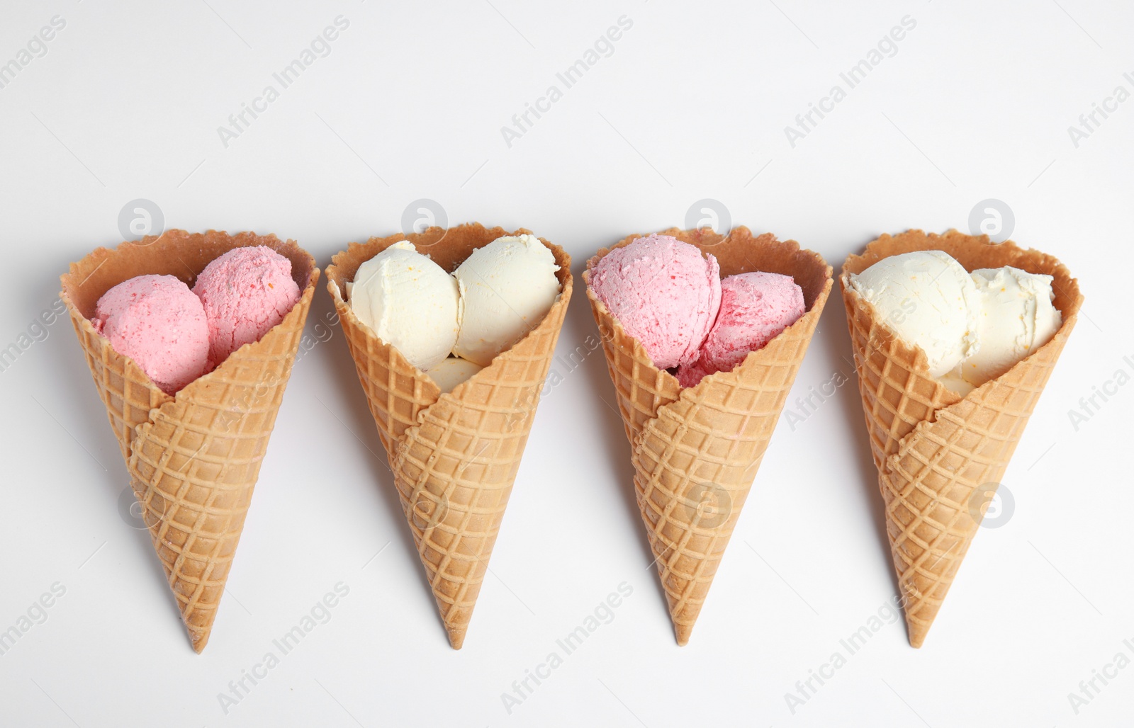 Photo of Delicious ice creams in wafer cones on white background, top view