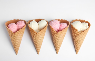 Photo of Delicious ice creams in wafer cones on white background, top view