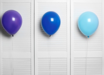 Different balloons near folding screen. Celebration time