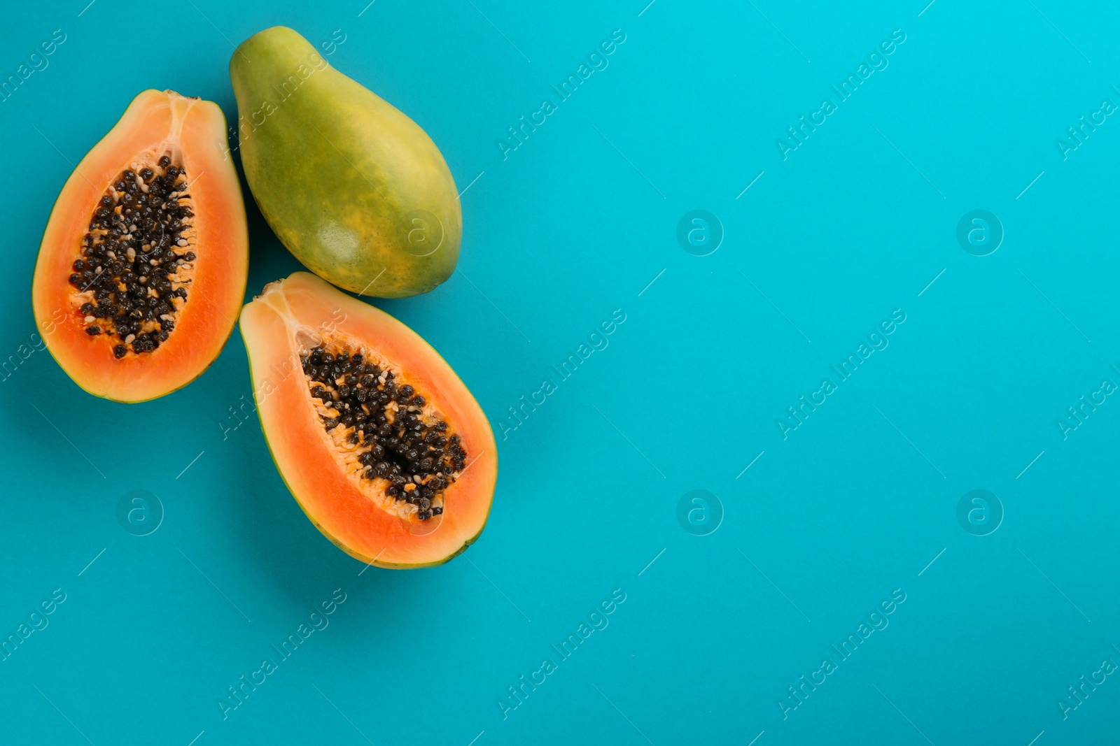 Photo of Fresh ripe papaya fruits on blue background, flat lay. Space for text
