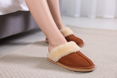 Woman in brown soft slippers at home, closeup