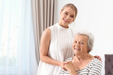 Happy young woman with her grandmother at home