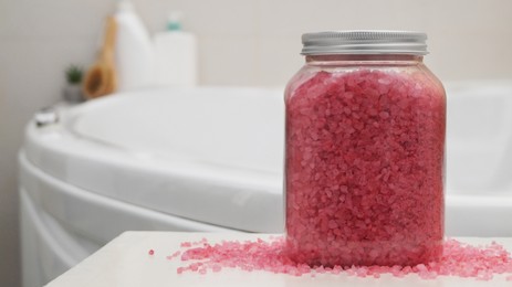 Jar with bath salt on table in bathroom, closeup. Space for text