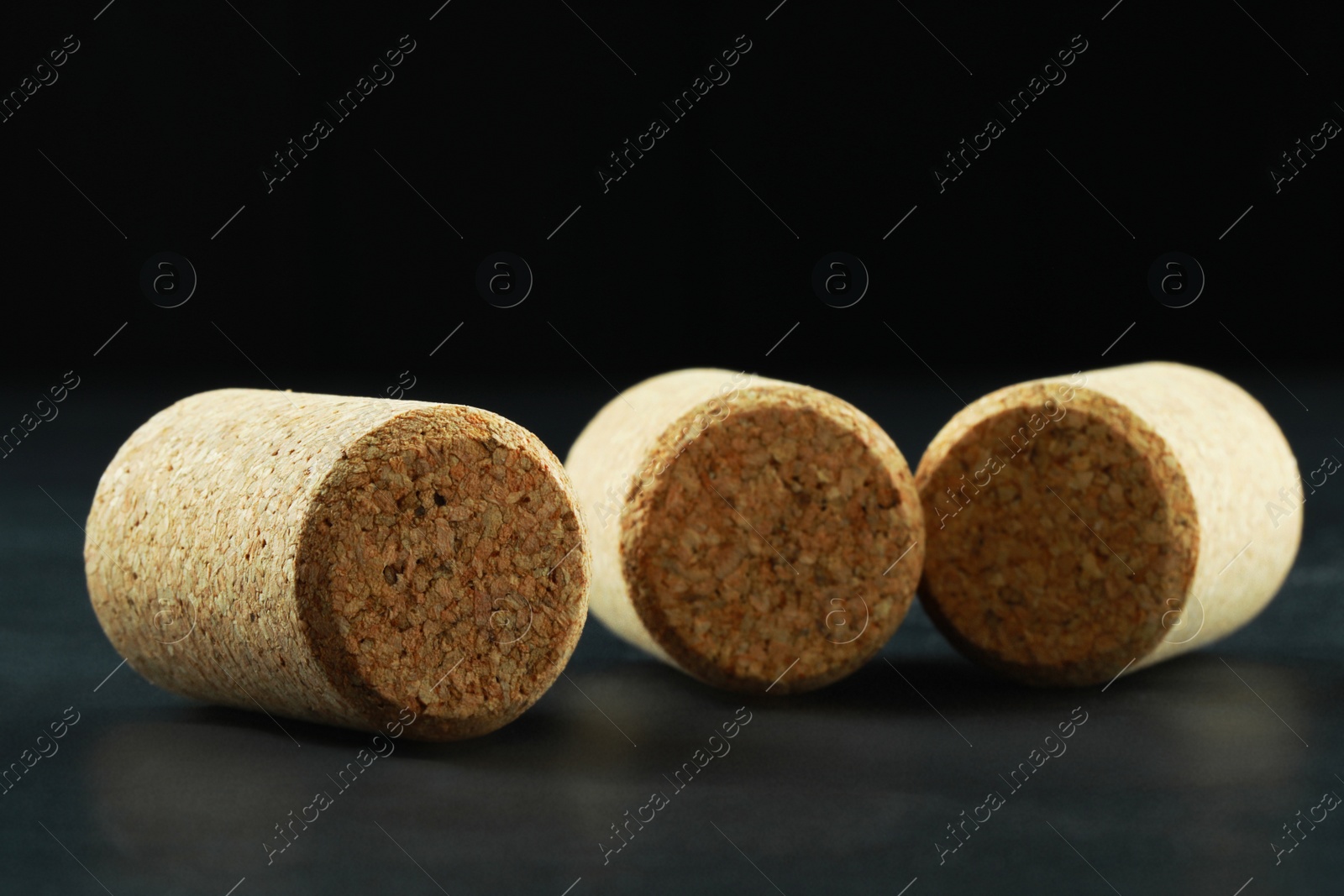 Photo of Corks of wine bottles on grey table, closeup