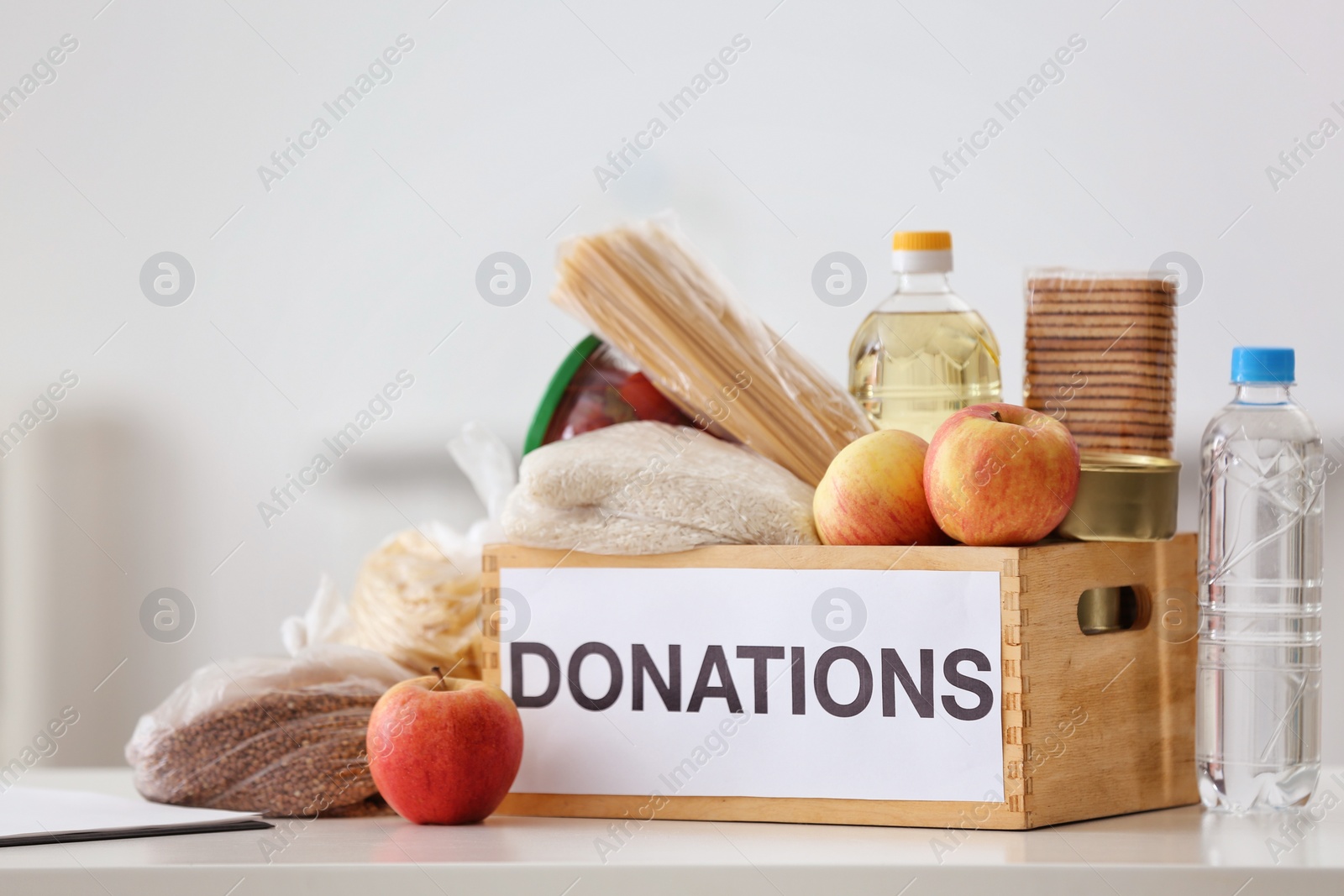 Photo of Donation box with food products on table indoors