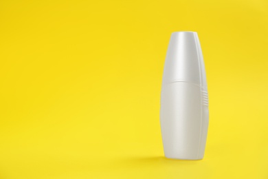 Bottle with insect repellent spray on yellow background, space for text