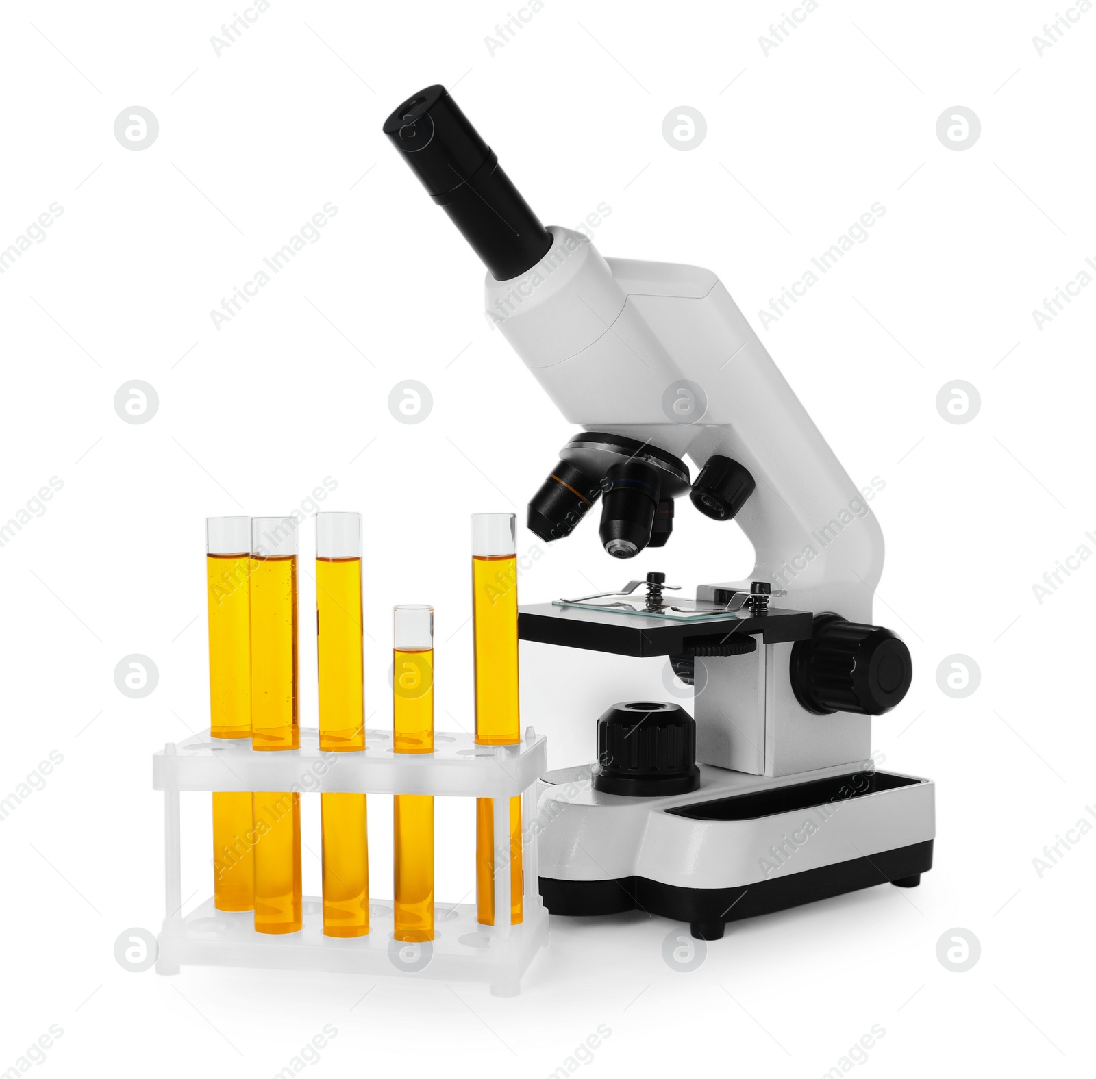 Photo of Test tubes with orange liquid and microscope isolated on white