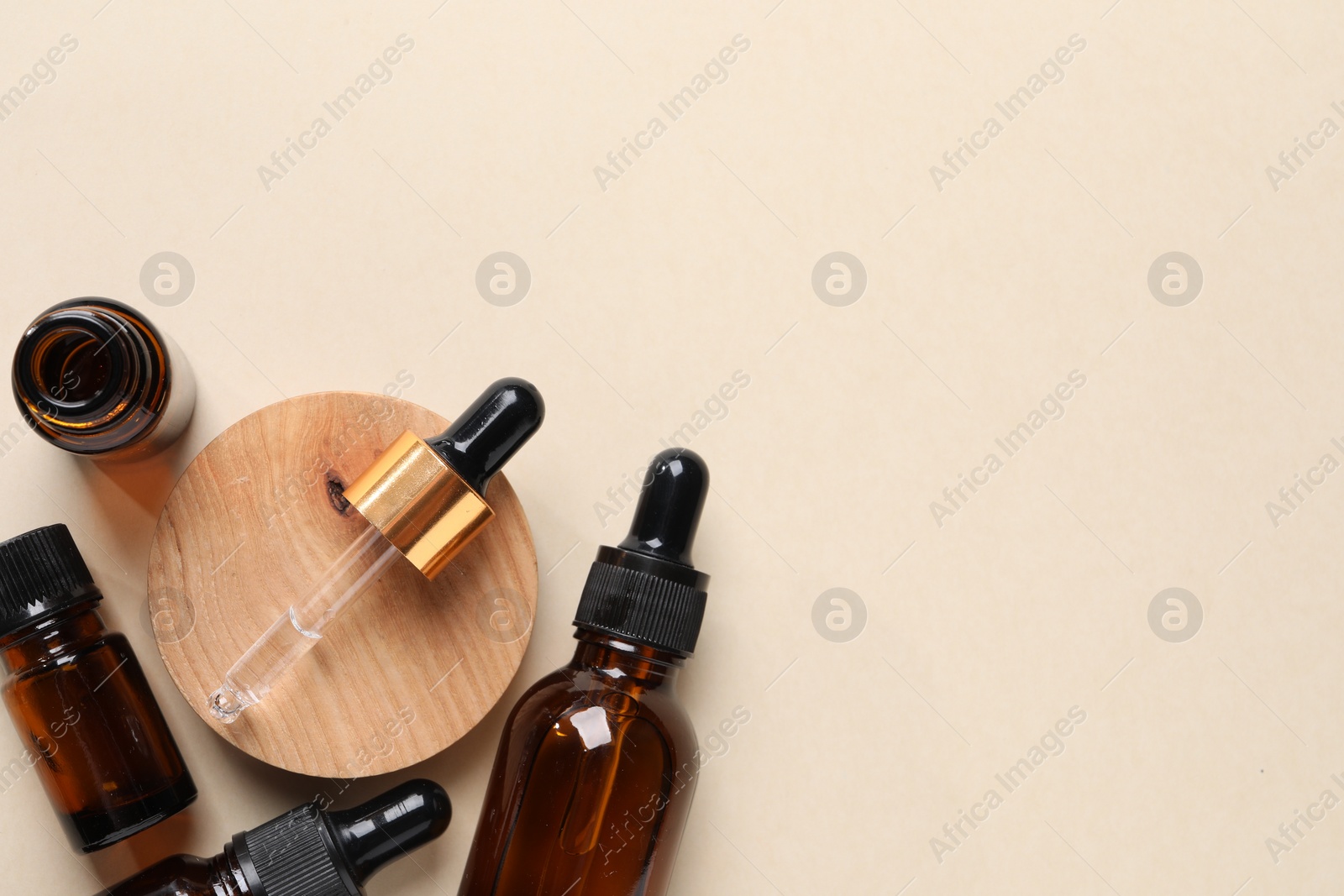 Photo of Bottles of cosmetic serum on beige background, flat lay. Space for text