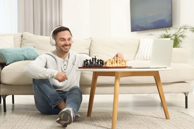 Photo of Teacher near chessboard conducting online lesson at home. Time for hobby