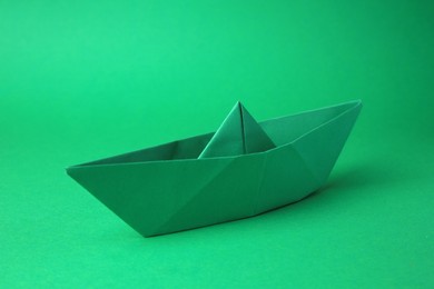 Origami art. Paper boat on green background