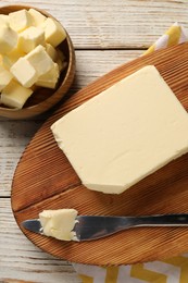 Photo of Tasty butter and knife on light wooden table, top view