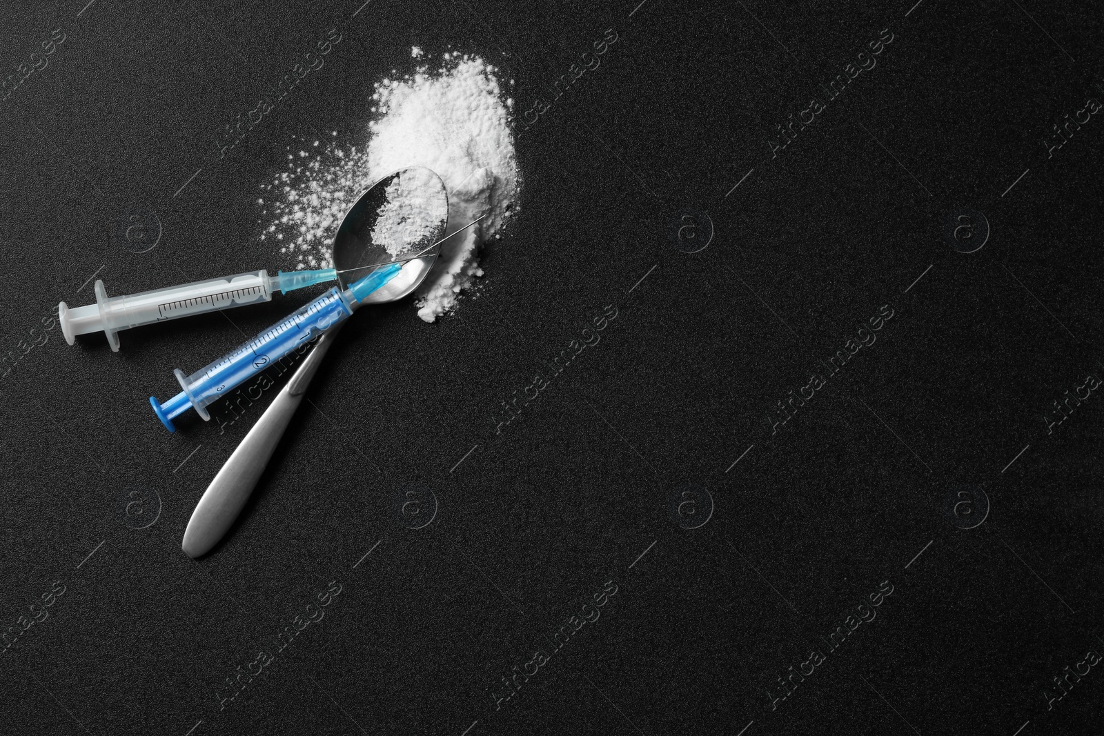 Photo of Flat lay composition with cocaine, spoon and syringes on dark background. Space for text