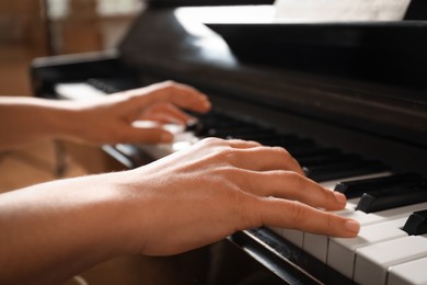 Photo of Young woman playing piano, closeup. Music lesson