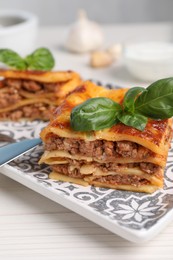 Delicious lasagna served on white table, closeup