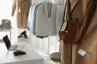 Collection of stylish women's clothes and accessories in modern boutique