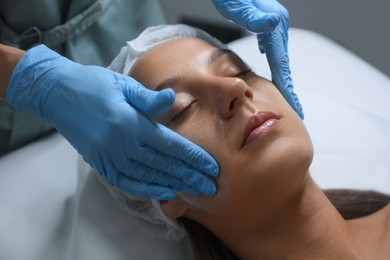 Photo of Young woman receiving facial massage in salon