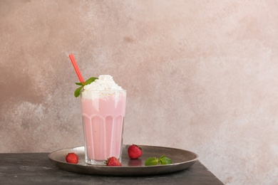 Glass with delicious milk shake on table