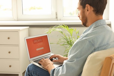 Man holding laptop with activated promo code at home