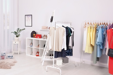 Photo of Wardrobe racks with different stylish clothes in light room