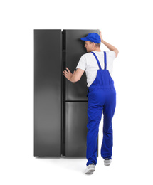 Photo of Professional worker carrying refrigerator on white background