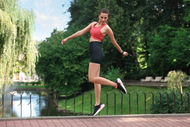 Photo of Beautiful woman in sportswear jumping in park