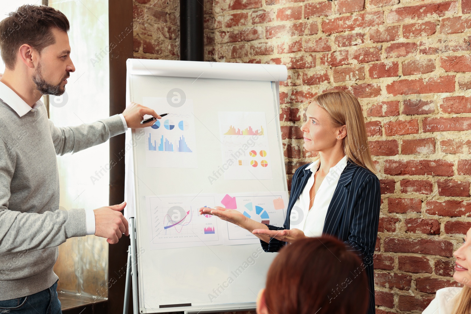 Photo of Businesswoman having meeting with her employees in office. Lady boss