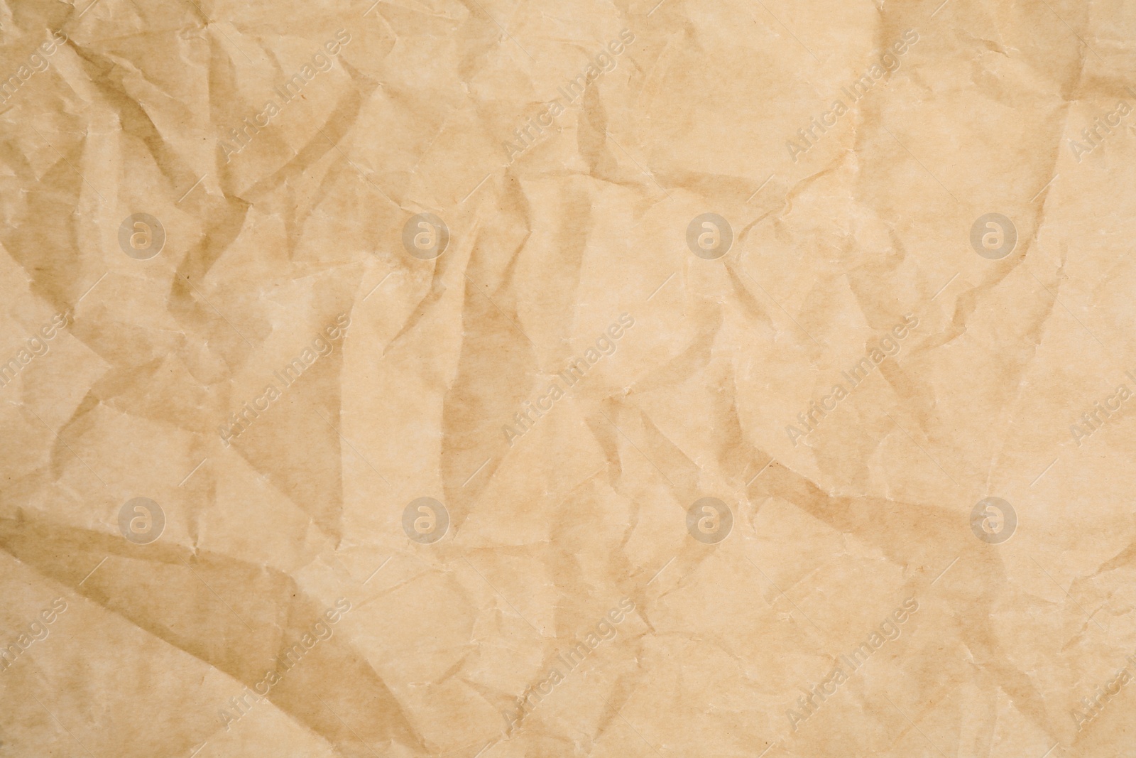 Photo of Texture of crumpled brown baking paper as background, closeup