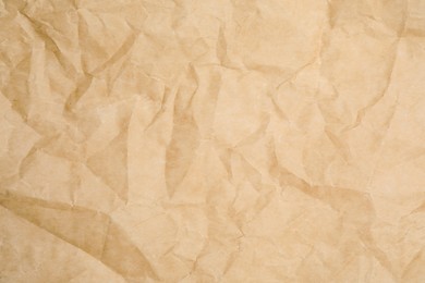 Texture of crumpled brown baking paper as background, closeup